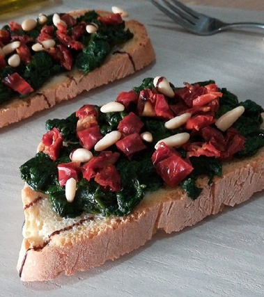 Bruschetta con spinaci, pomodori secchi e pinoli