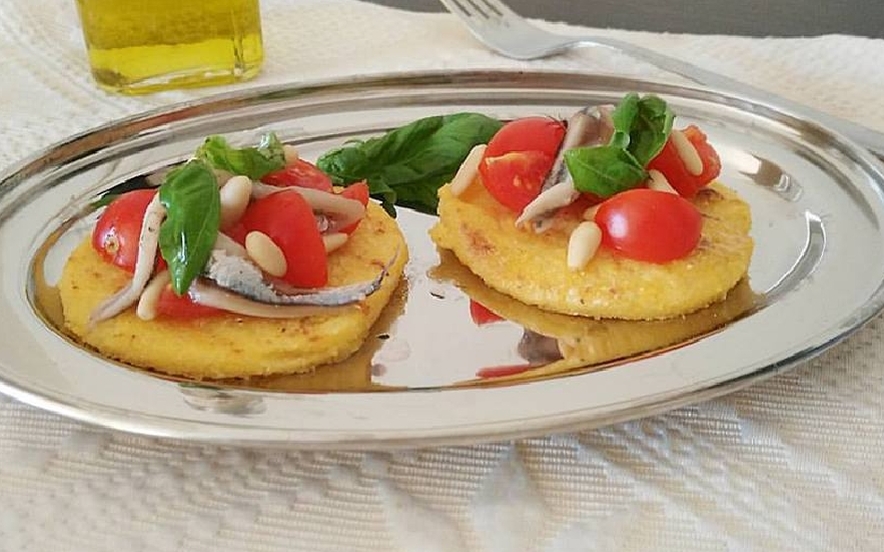 Crostini di polenta con alici marinate e pinoli