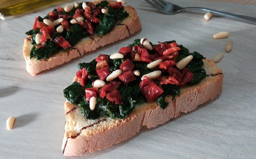 Bruschetta con spinaci, pomodori secchi e pinoli